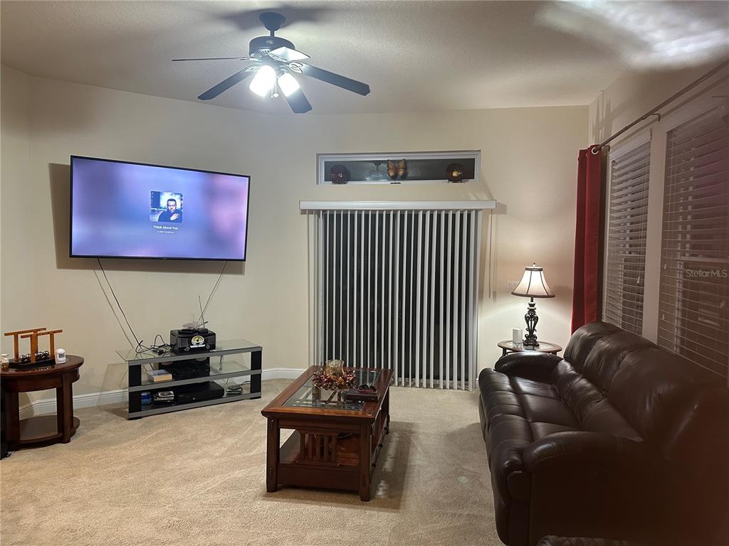 7739 Seafield Lane Wesley Chapel, FL 33545 - Photo 4 of 10 a living room with furniture and a chandelier