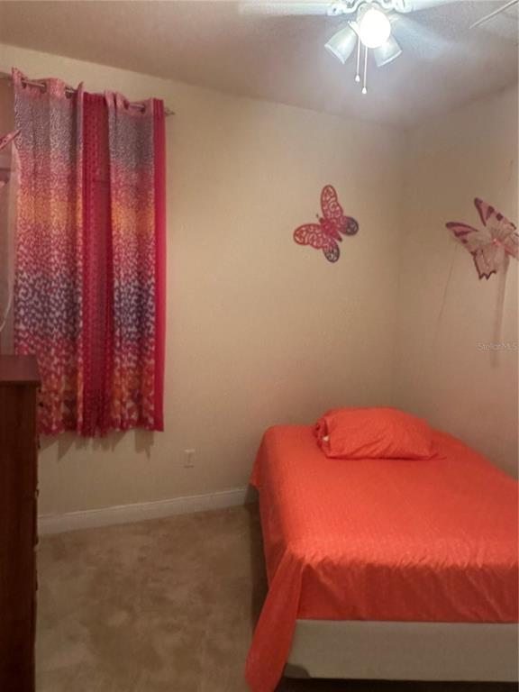 7739 Seafield Lane Wesley Chapel, FL 33545 - Photo 9 of 10 a bedroom with a bed and a chandelier