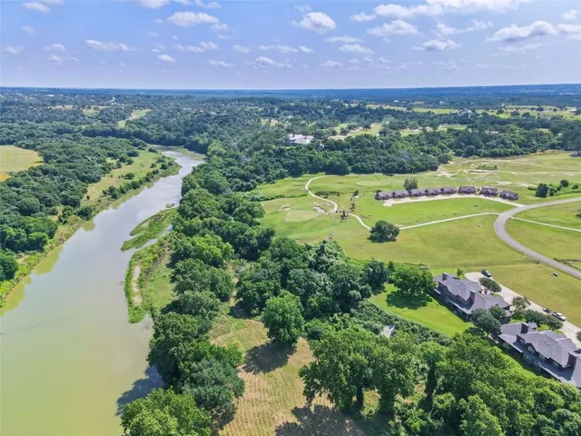 an aerial view of a golf course with a lake view