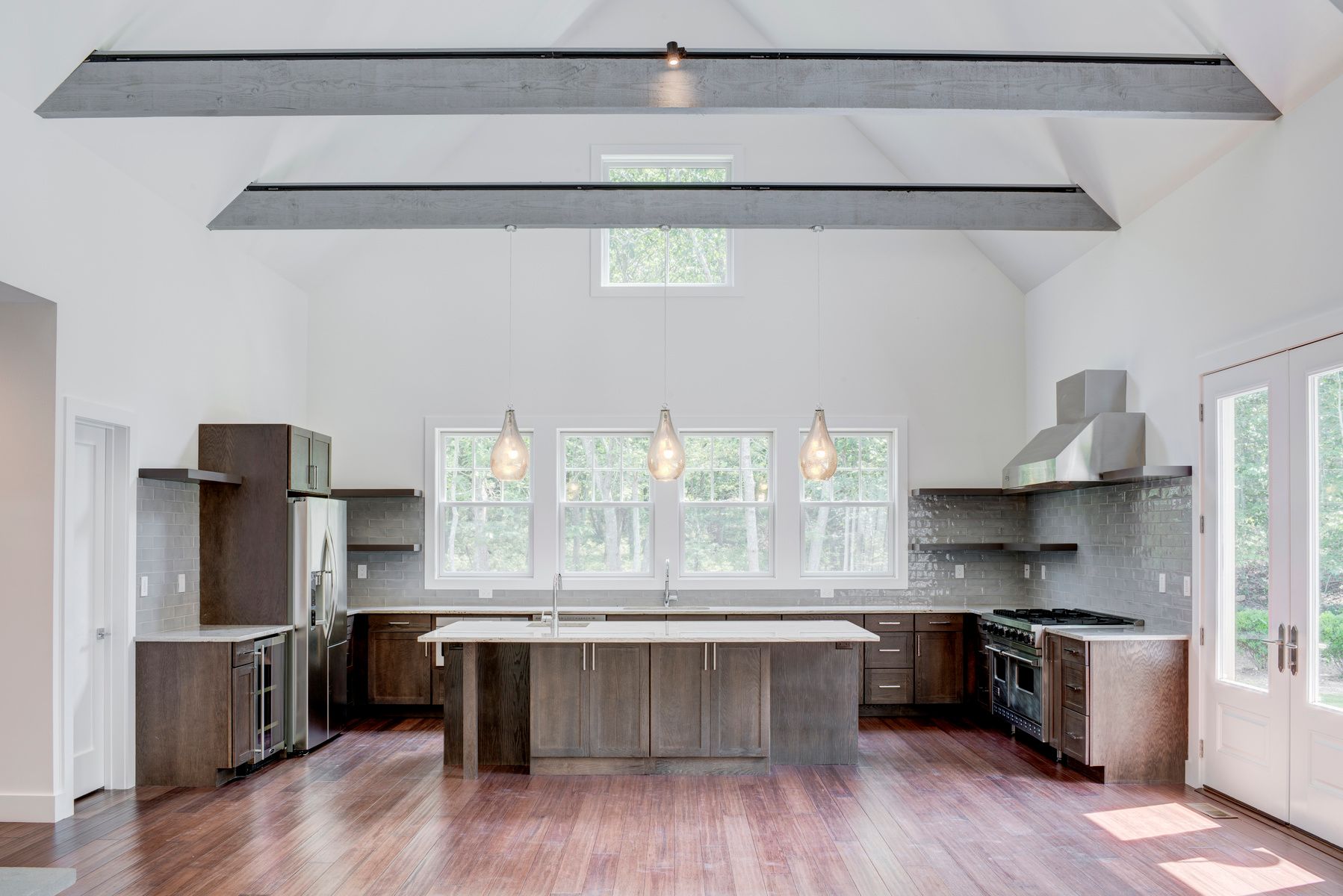 114 Three Mile Harbor Road East Hampton, NY 11937 - Photo 6 of 14 a kitchen with stainless steel appliances wooden floors and wooden cabinets