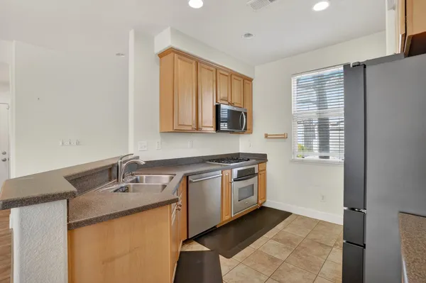a kitchen with stainless steel appliances granite countertop a sink stove and microwave