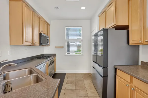 a kitchen with a refrigerator sink and cabinets