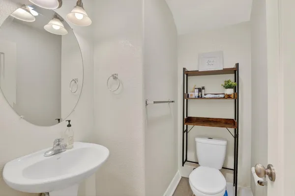 a bathroom with a toilet sink and mirror