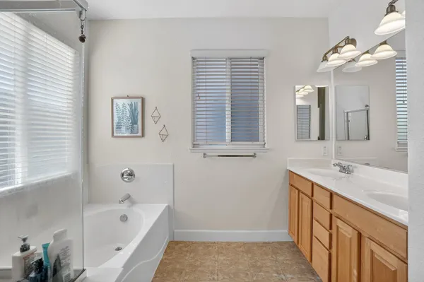 a bathroom with a tub sink and mirror