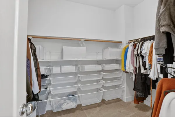 a view of walk in closet with clothes and shoes