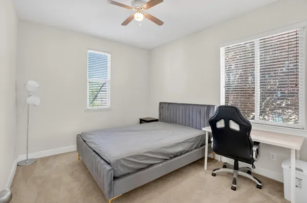 a bedroom with a bed window and chair