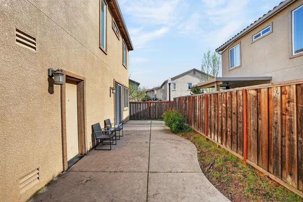 a view of a patio with table and chairs and wooden fence