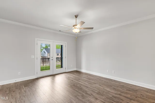 a view of an empty room with window and wooden floor