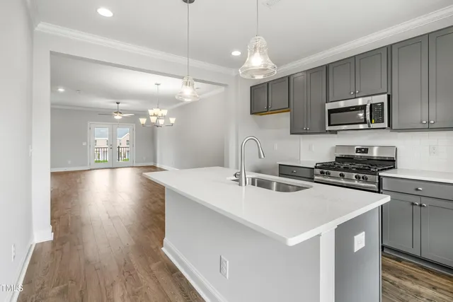 a kitchen that has a sink a microwave a stove and cabinets