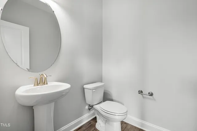 a bathroom with a sink toilet and a mirror