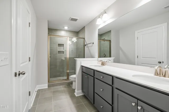 a bathroom with a double vanity sink mirror double and shower