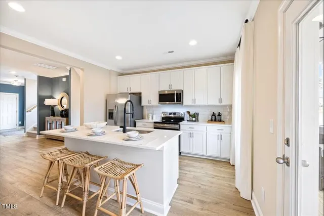 a kitchen with a refrigerator a stove cabinets and wooden floor