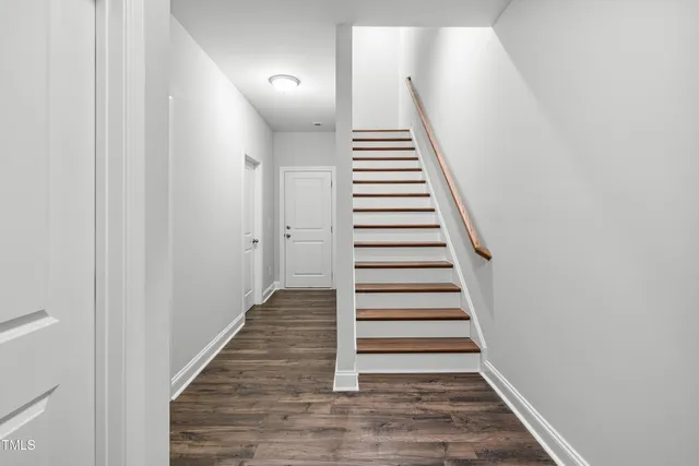 a view of a hallway with wooden floor and entryway