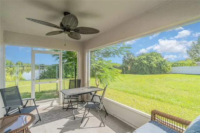 a living room with patio furniture and a floor to ceiling window