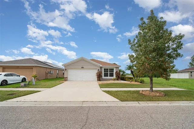 a front view of a house with a yard and trees