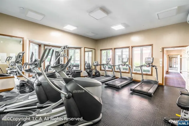 a living room with furniture gym equipment and a large window