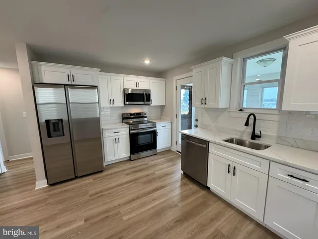 a view of a kitchen with sink cabinets and wooden floor
