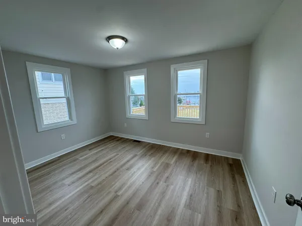 an empty room with wooden floor and a window