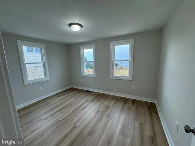 an empty room with wooden floor and a window