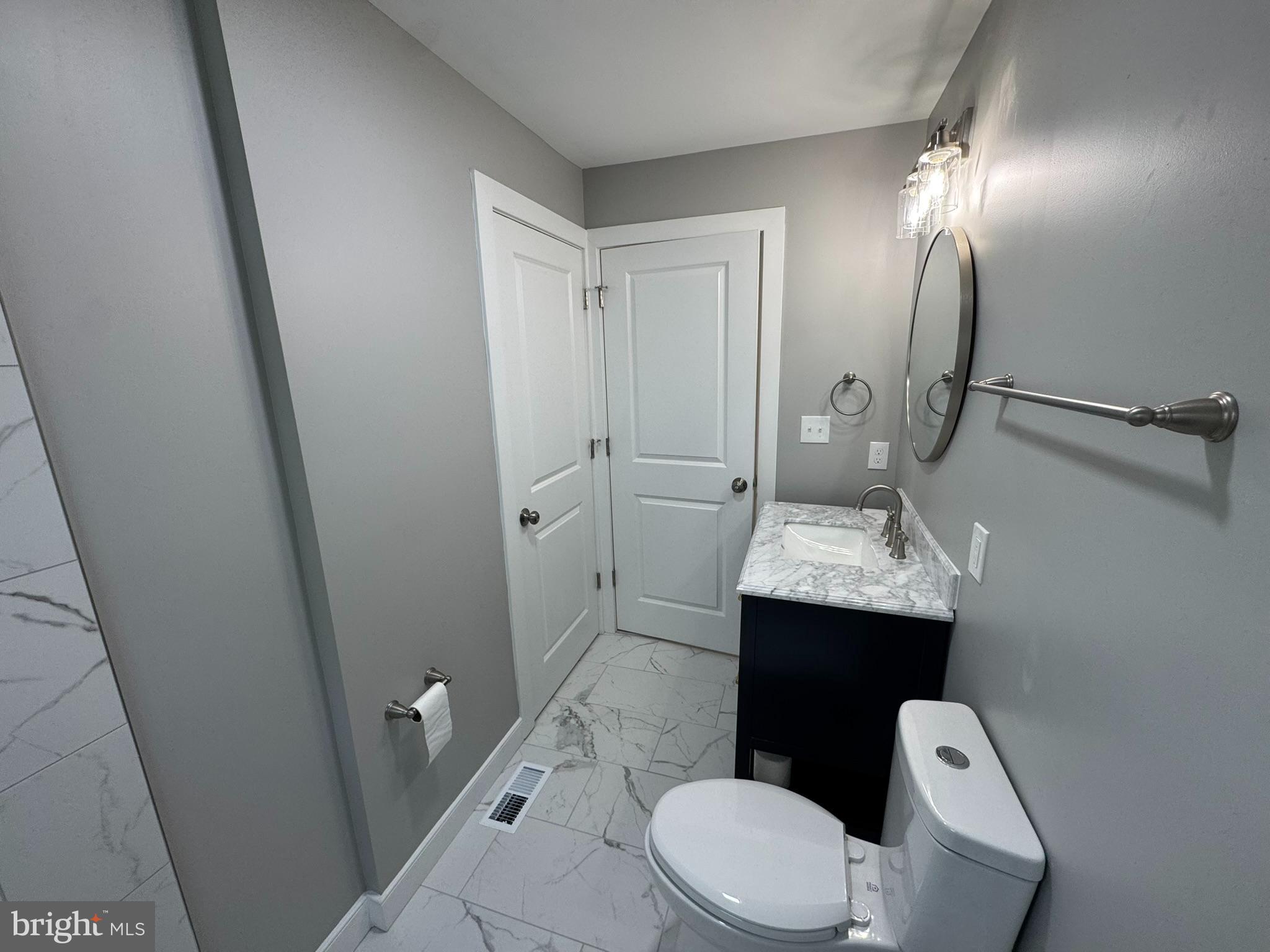 9135 Cuckold Point Road Sparrows Point, MD 21219 - Photo 33 of 53 a bathroom with a toilet sink and mirror