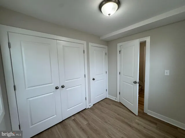 a view of a closet area with furniture and wooden floor