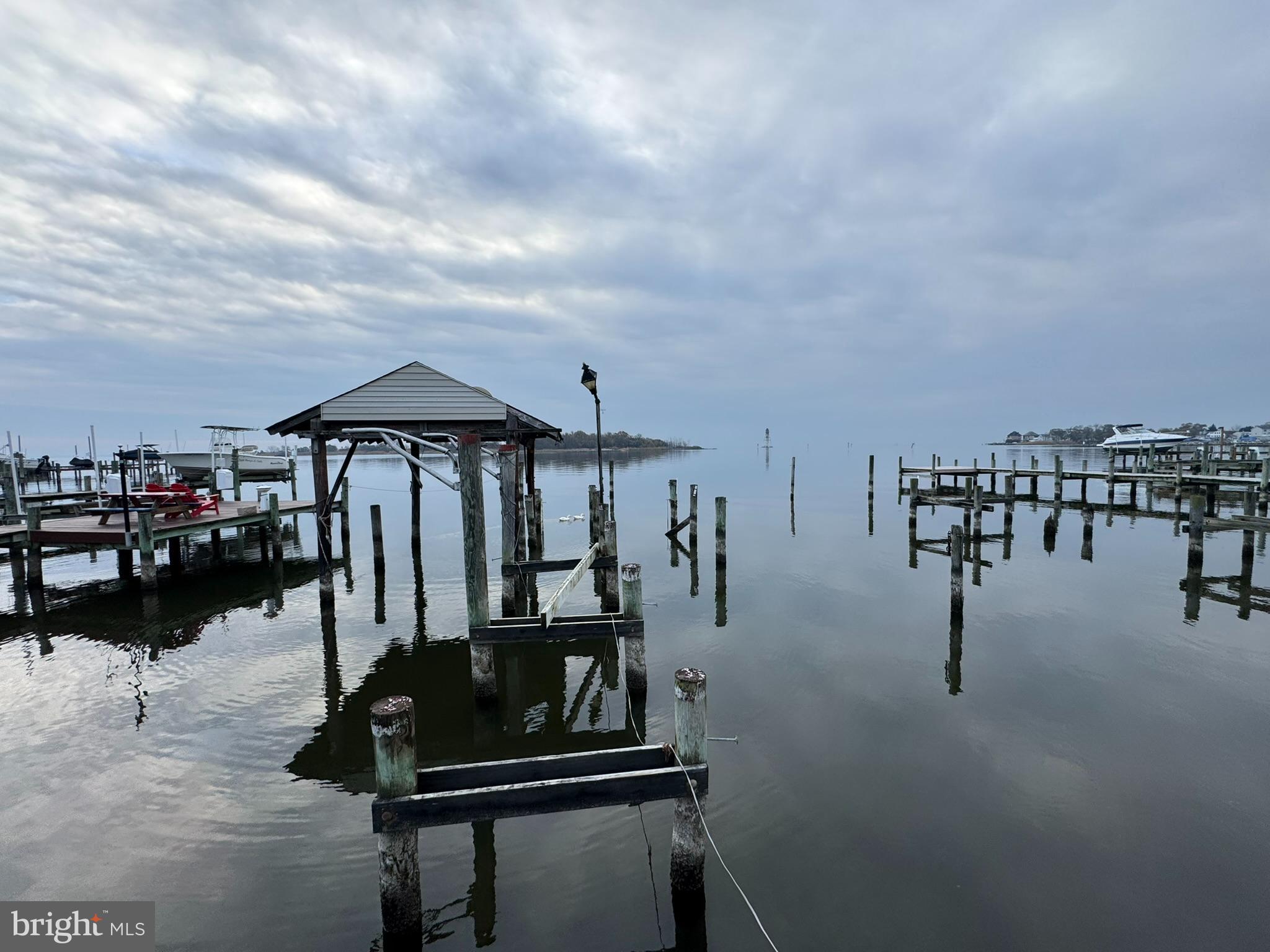 9135 Cuckold Point Road Sparrows Point, MD 21219 - Photo 7 of 53 a roof deck with table and chairs a barbeque
