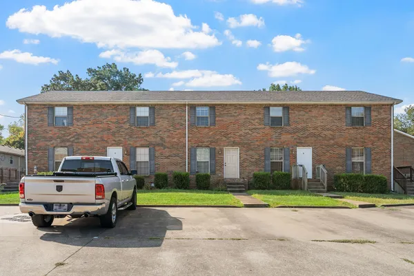 a car parked in front of a brick house