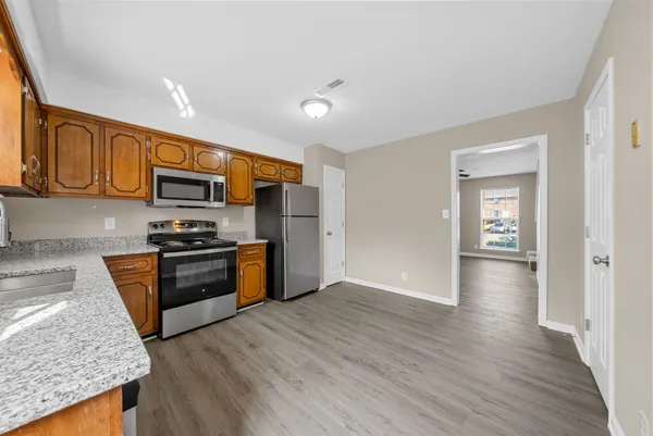 a kitchen with stainless steel appliances granite countertop wooden cabinets a stove top oven a sink and dishwasher