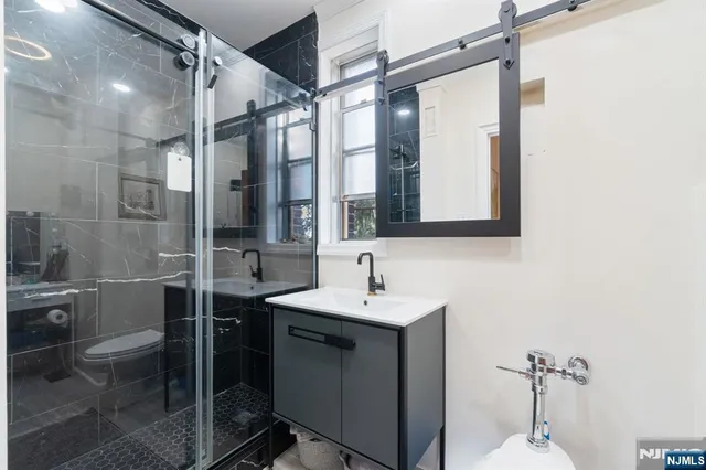 a bathroom with a sink shower and a mirror