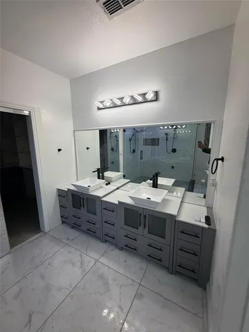 a spacious bathroom with a double vanity sink and a mirror