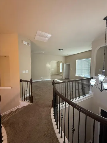 a view of hallway with a large window and wooden floor