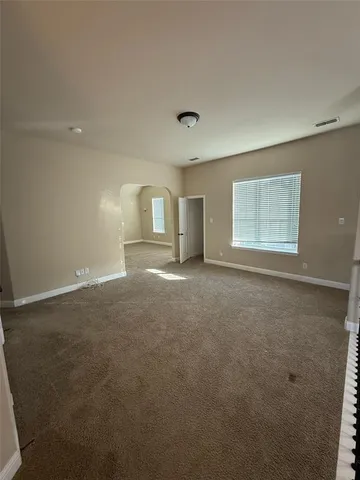 an empty room with windows and fireplace