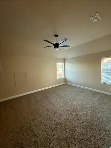 an empty room with windows and ceiling fan