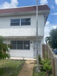 1480 Northeast 151st Street, Unit 101 North Miami Beach, FL 33162 - Photo 1 of 4 a front view of a house with a yard