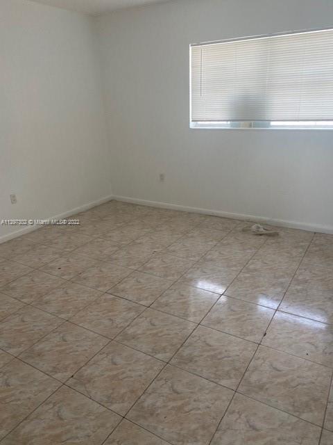 1480 Northeast 151st Street, Unit 101 North Miami Beach, FL 33162 - Photo 4 of 4 a view of a room with an empty space and window