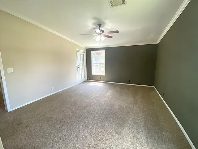 an empty room with a window and a ceiling fan