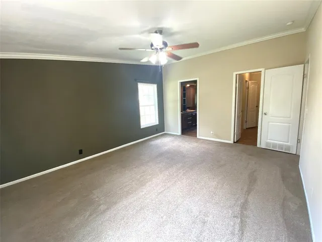 a view of a big room with windows and chandelier fan
