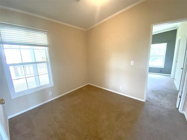 a view of a hallway with wooden floor and a bathroom