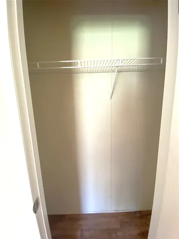 an empty room with wooden floor chandelier fan and windows