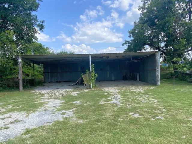 a view of a house with backyard and a tree