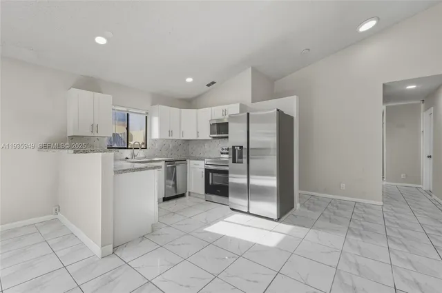 a kitchen with white cabinets and white appliances