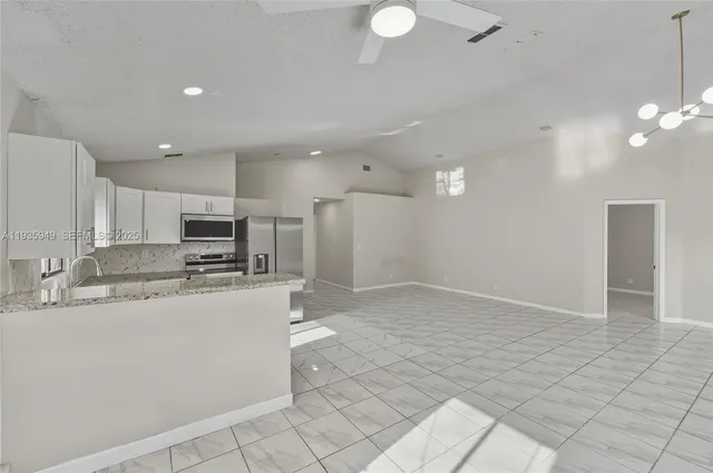 a kitchen with stainless steel appliances a refrigerator sink and microwave