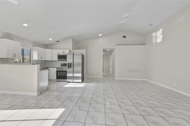 a kitchen with stainless steel appliances a refrigerator sink and cabinets