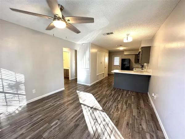 a view of a dining room and livingroom with furniture wooden floor a chandelier
