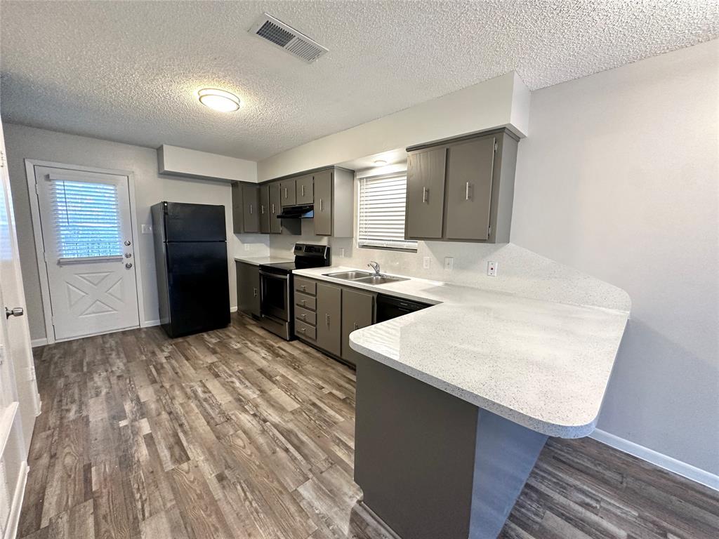 2006 Jane Street, Unit C Longview, TX 75601 - Photo 11 of 12 a kitchen with stainless steel appliances granite countertop a sink stove refrigerator and cabinets