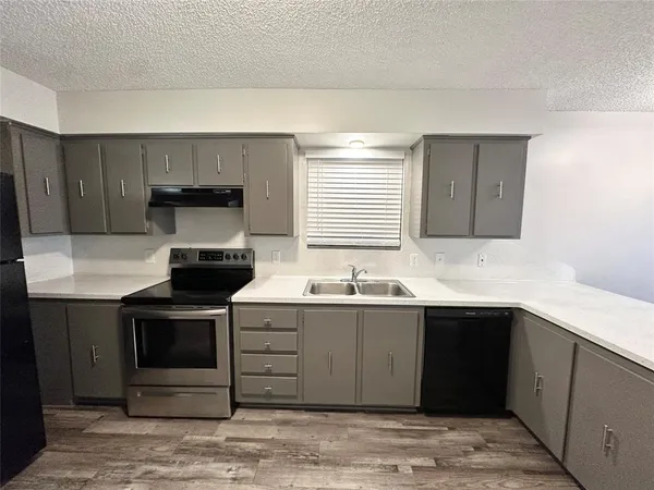 a kitchen with stainless steel appliances a stove a sink and a microwave