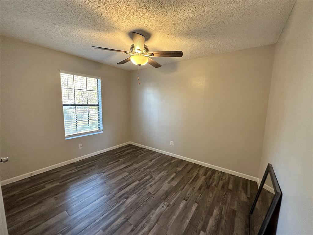 2006 Jane Street, Unit C Longview, TX 75601 - Photo 9 of 12 a view of an empty room with wooden floor and a window