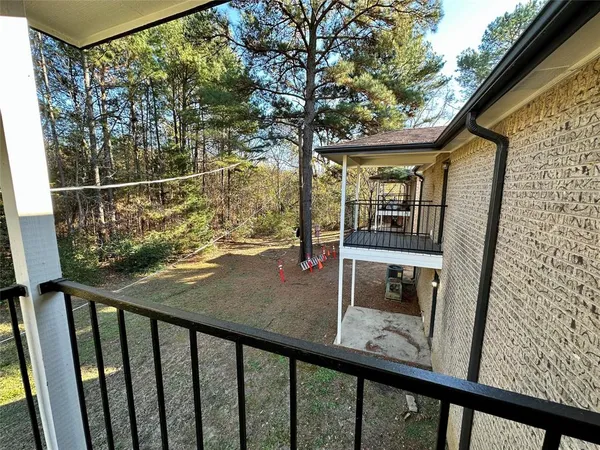 a view of balcony with wooden floor and fence