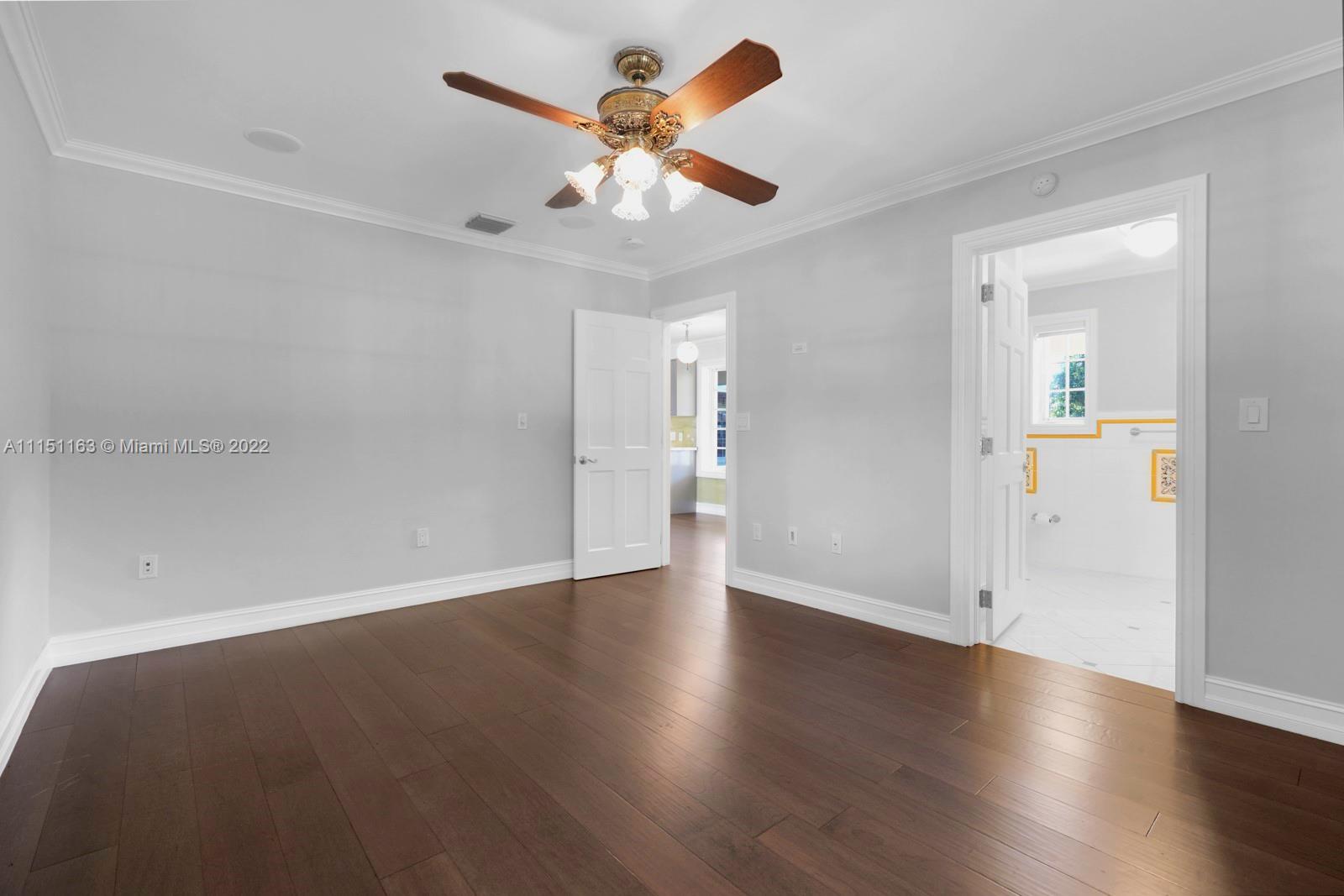 13920 Stirling Road Southwest Ranches, FL 33330 - Photo 39 of 98 an empty room with wooden floor chandelier fan and windows