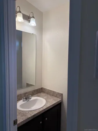 a bathroom with a granite countertop sink and a mirror